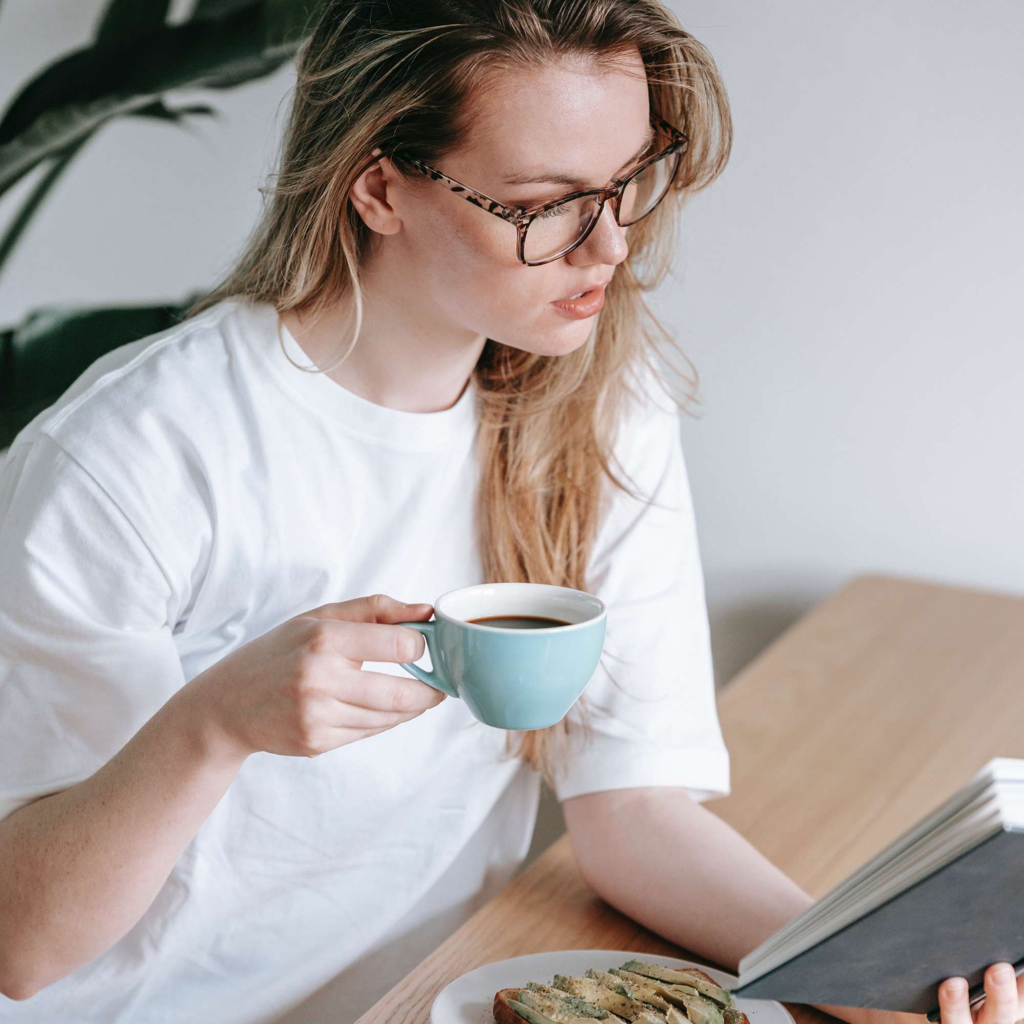 Ein Mädchen frühstückt und liest ein Buch über Essgewohnheiten – I·DO