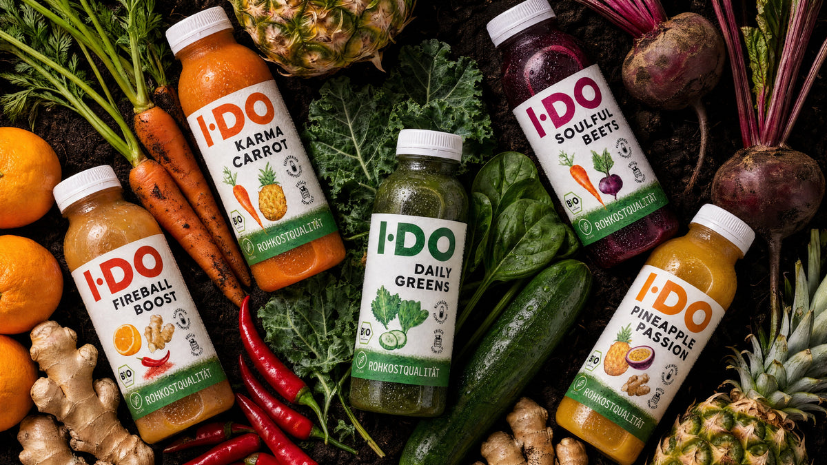 Fünf I·DO Säfte auf rohem Bio-Gemüse: Daily Greens, Karma Carrot, Soulful Beets, Fireball Boost und Pineapple Passion