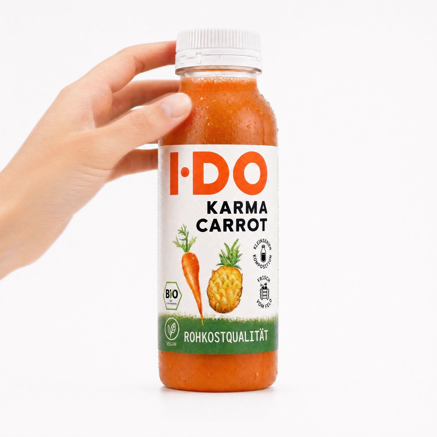 Karma Carrot – I·DO Bio-Saft, 240-ml-Flasche in der Hand